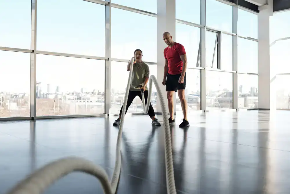 Two people working out together with a trainer