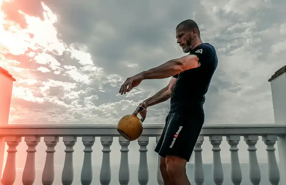 Client doing kettlebell swings in a living room